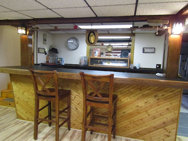 bar featuring wood-type flooring and a drop ceiling