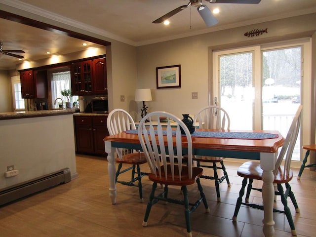 dining room with ornamental molding, a baseboard heating unit, and ceiling fan