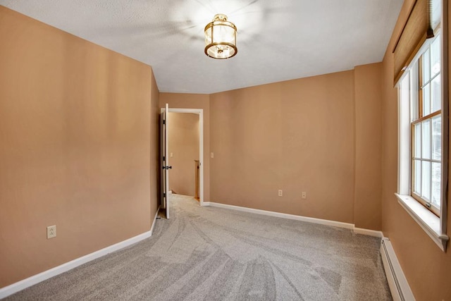 unfurnished room featuring carpet and a baseboard heating unit