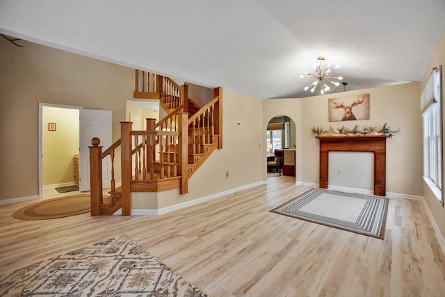 living room featuring wood-type flooring, lofted ceiling, and a notable chandelier