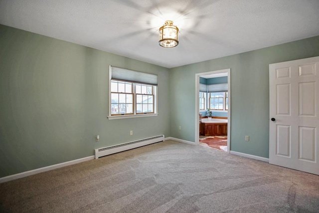 unfurnished bedroom featuring carpet floors, baseboard heating, and ensuite bathroom