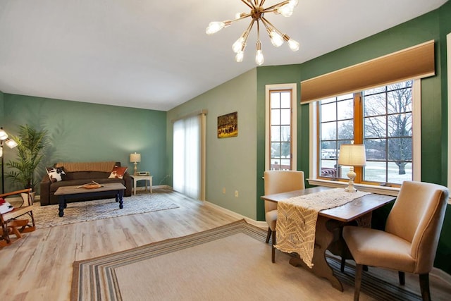 living area featuring wood-type flooring, plenty of natural light, and a notable chandelier