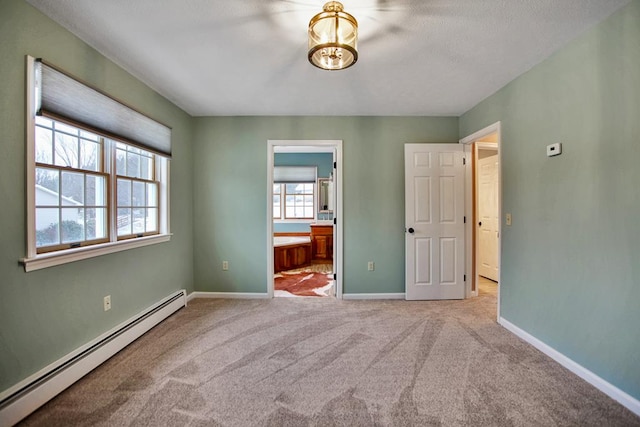 unfurnished bedroom with connected bathroom, light colored carpet, and baseboard heating