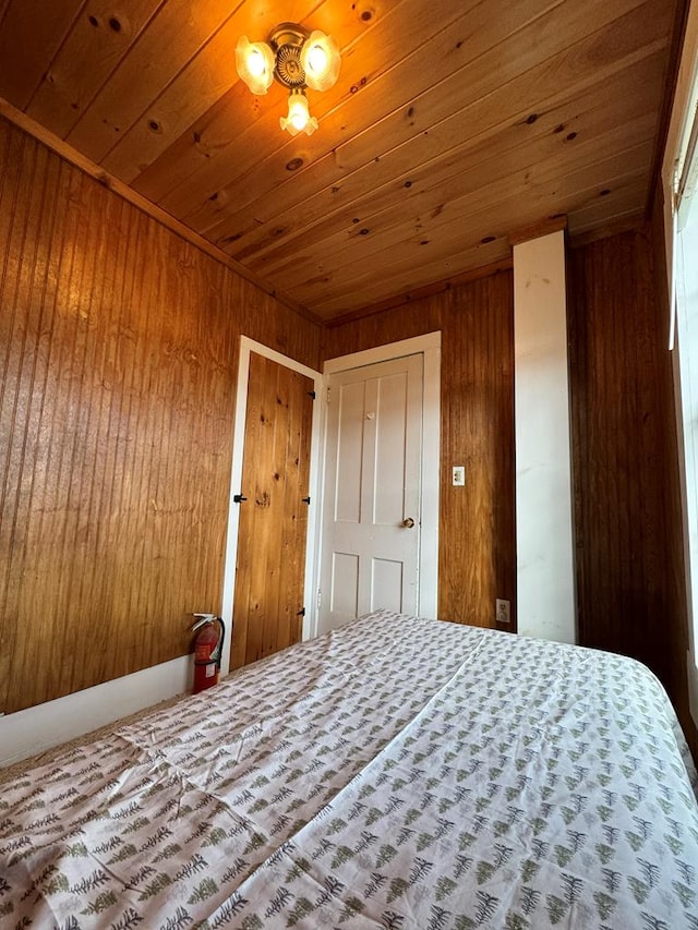 unfurnished bedroom featuring wood walls and wood ceiling