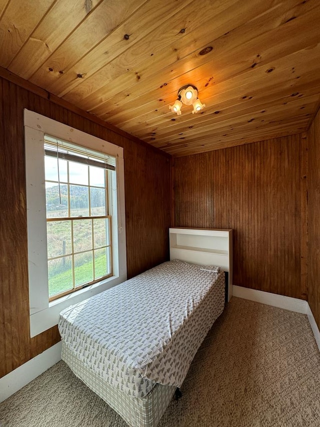 carpeted bedroom with wood walls and wood ceiling