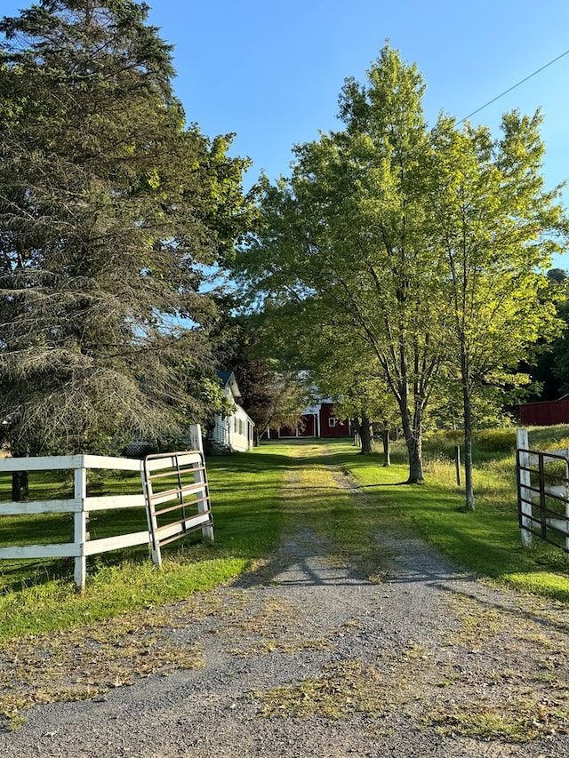 view of gate with a rural view and a yard