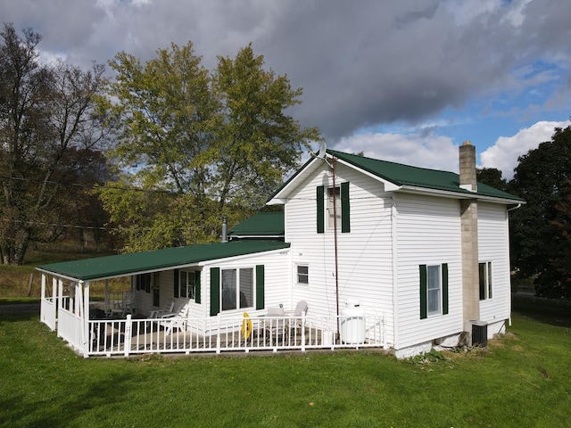 back of property featuring central AC, a yard, and a porch