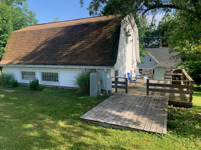 back of property featuring a deck and a yard