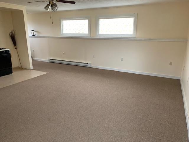 spare room with ceiling fan, a healthy amount of sunlight, carpet floors, and a baseboard radiator