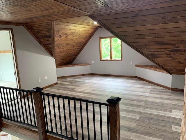 additional living space with wood-type flooring, vaulted ceiling, and wood ceiling