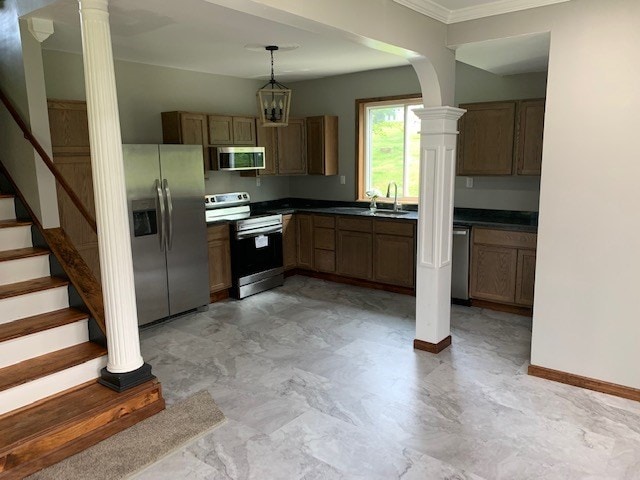 kitchen featuring stainless steel appliances, crown molding, sink, decorative light fixtures, and an inviting chandelier