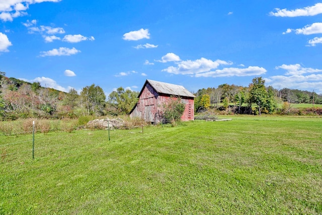 view of yard featuring a rural view and an outbuilding