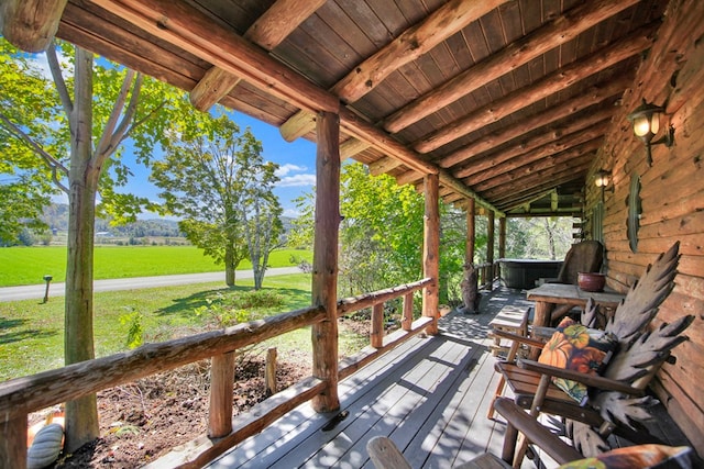 wooden deck with a rural view and a hot tub