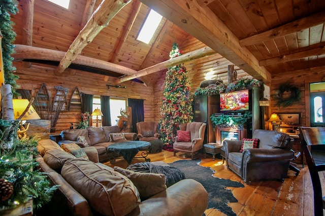 living room featuring beam ceiling, a skylight, rustic walls, and wood ceiling