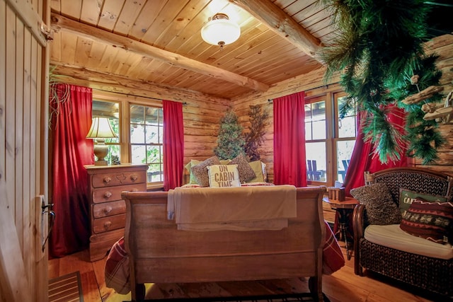 bedroom with multiple windows, beamed ceiling, log walls, and wood-type flooring