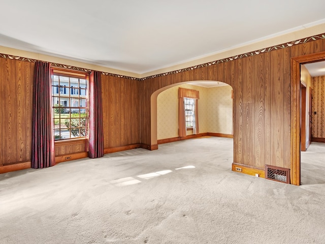 empty room with crown molding and carpet floors