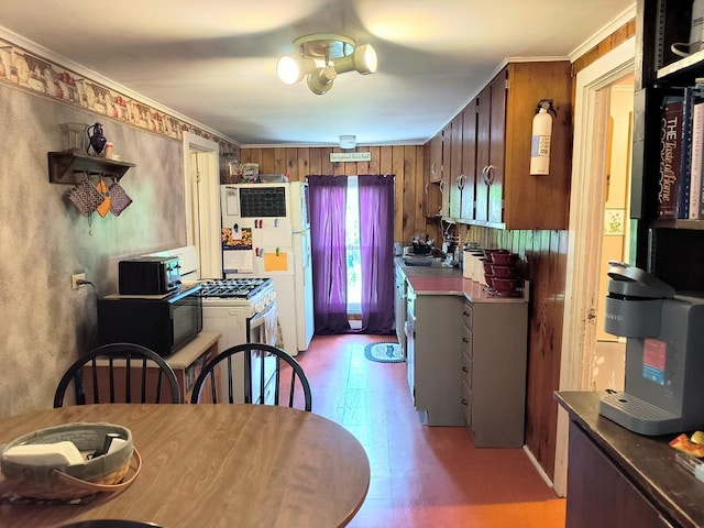 2826 Austinville Rd, Troy, PA 16947 - kitchen with white appliances, crown molding, brown cabinetry, light floors, and wooden walls