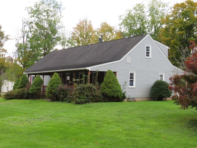 rear view of property featuring a lawn and covered porch