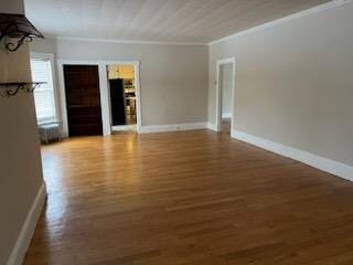 unfurnished room featuring wood-type flooring and ornamental molding