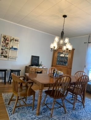 dining space featuring a chandelier, crown molding, and wood-type flooring