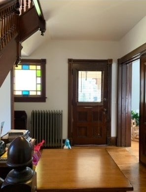 entryway featuring radiator heating unit, vaulted ceiling, and hardwood / wood-style flooring