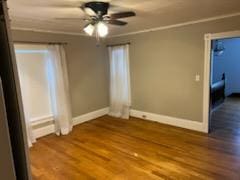 spare room with hardwood / wood-style floors, a baseboard heating unit, ceiling fan, and crown molding