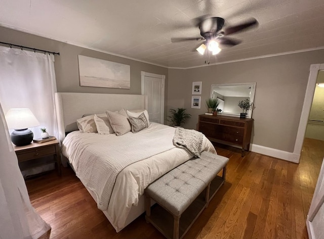 bedroom with ceiling fan, dark hardwood / wood-style floors, and crown molding