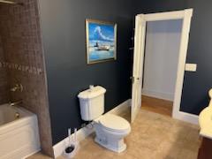 bathroom with toilet and washtub / shower combination