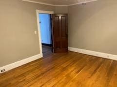 empty room featuring hardwood / wood-style floors and ornamental molding