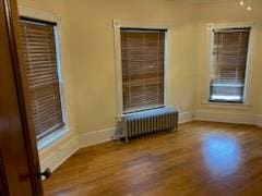 empty room featuring hardwood / wood-style flooring and radiator