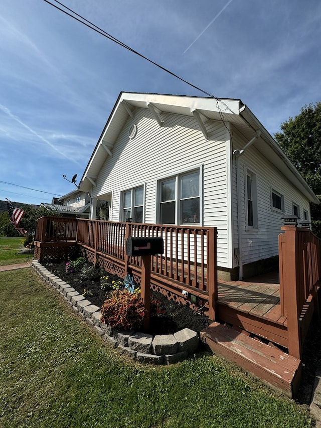 back of house with a lawn and a deck