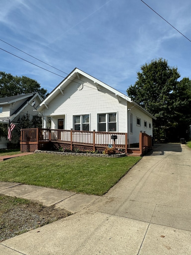 view of front of house featuring a front lawn and a deck