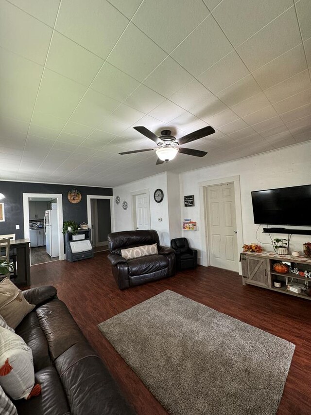 living room featuring dark wood-type flooring and ceiling fan