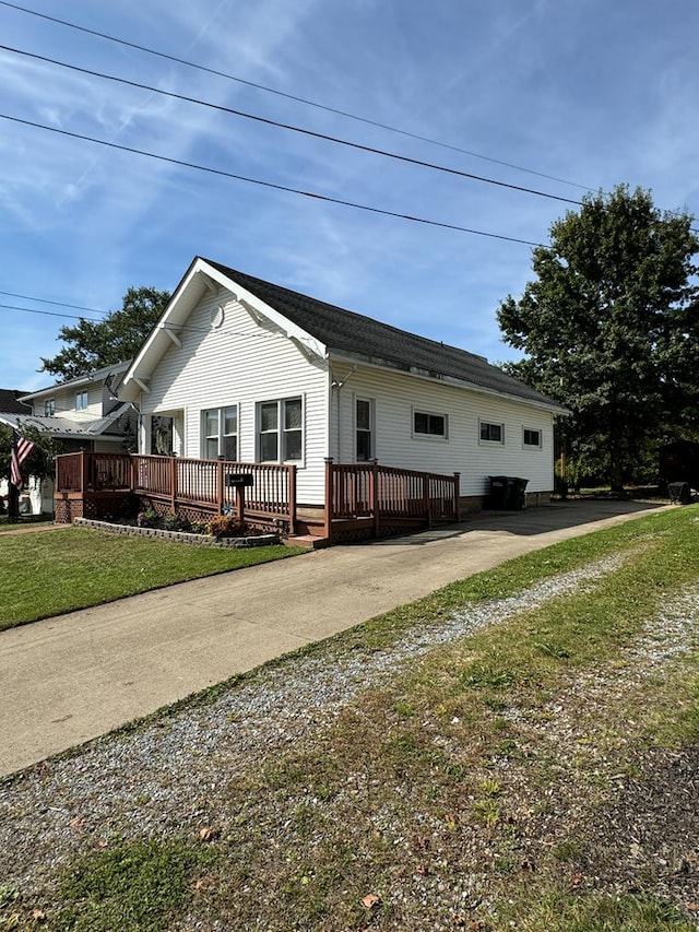 view of front facade featuring a wooden deck and a front lawn