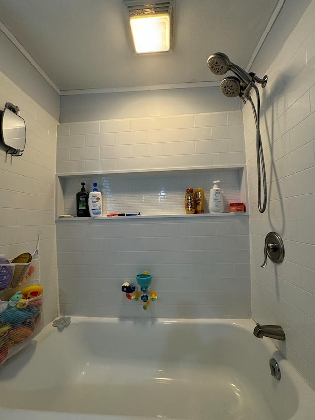 bathroom with crown molding and tiled shower / bath