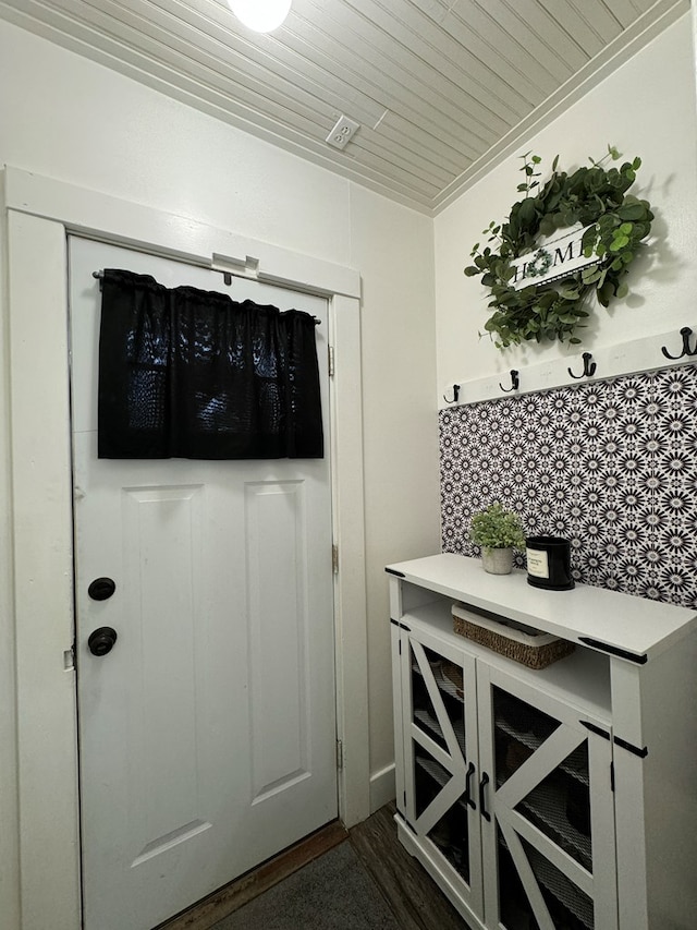 doorway with crown molding and wood ceiling