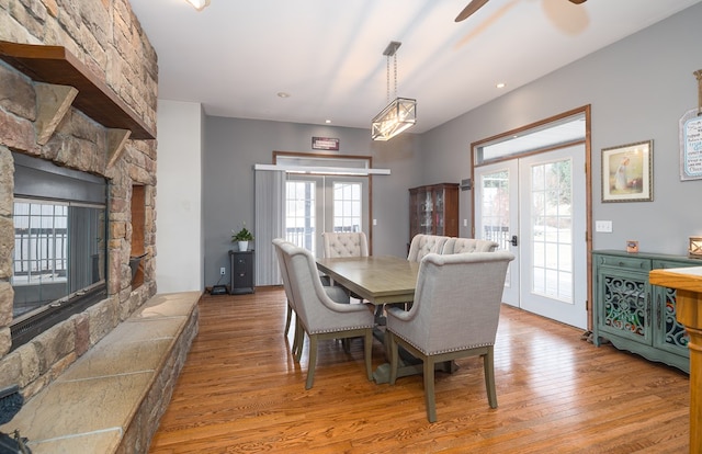 dining space featuring french doors, wood finished floors, and a fireplace