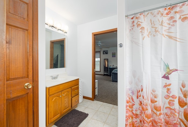 bathroom featuring a shower with shower curtain, baseboards, and vanity