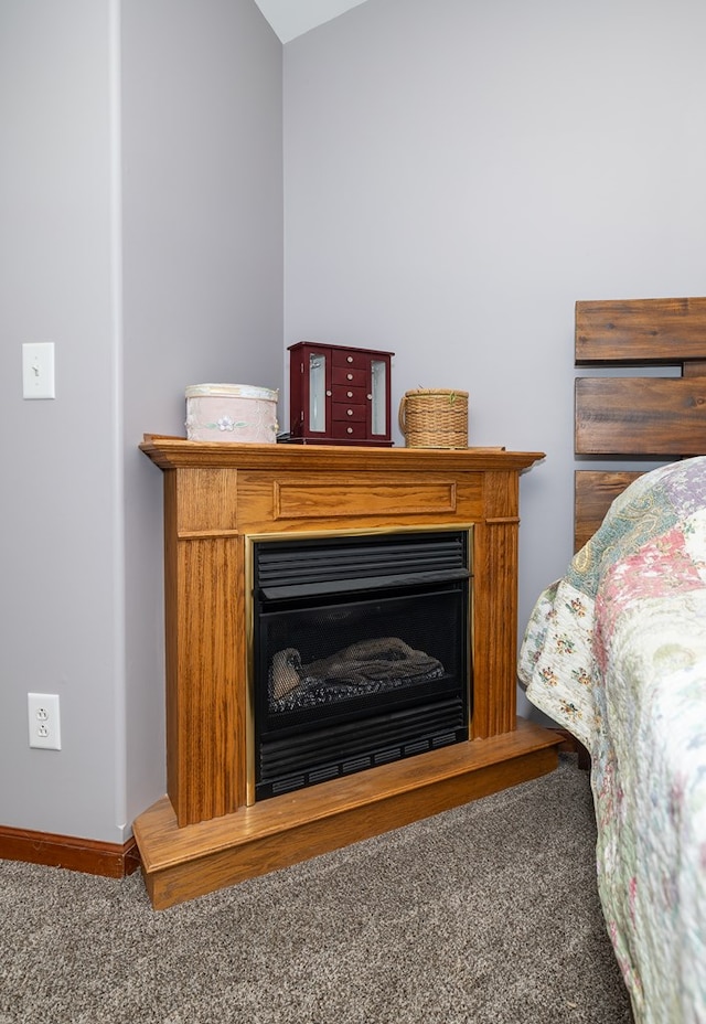 carpeted bedroom featuring baseboards and a fireplace