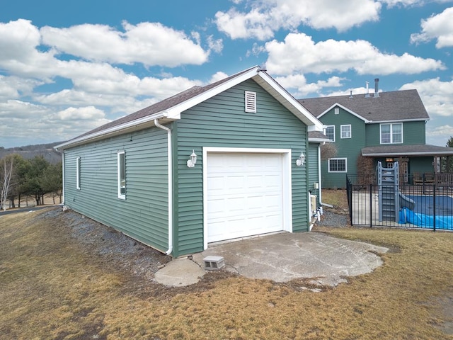 garage with driveway and fence