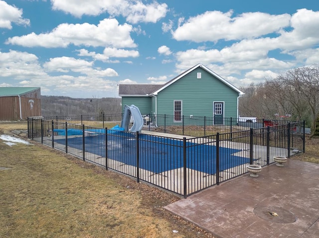 view of pool featuring a patio area, a fenced in pool, a water slide, and fence