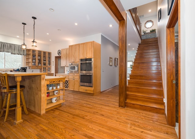 kitchen featuring light wood-style flooring, open shelves, recessed lighting, appliances with stainless steel finishes, and light countertops