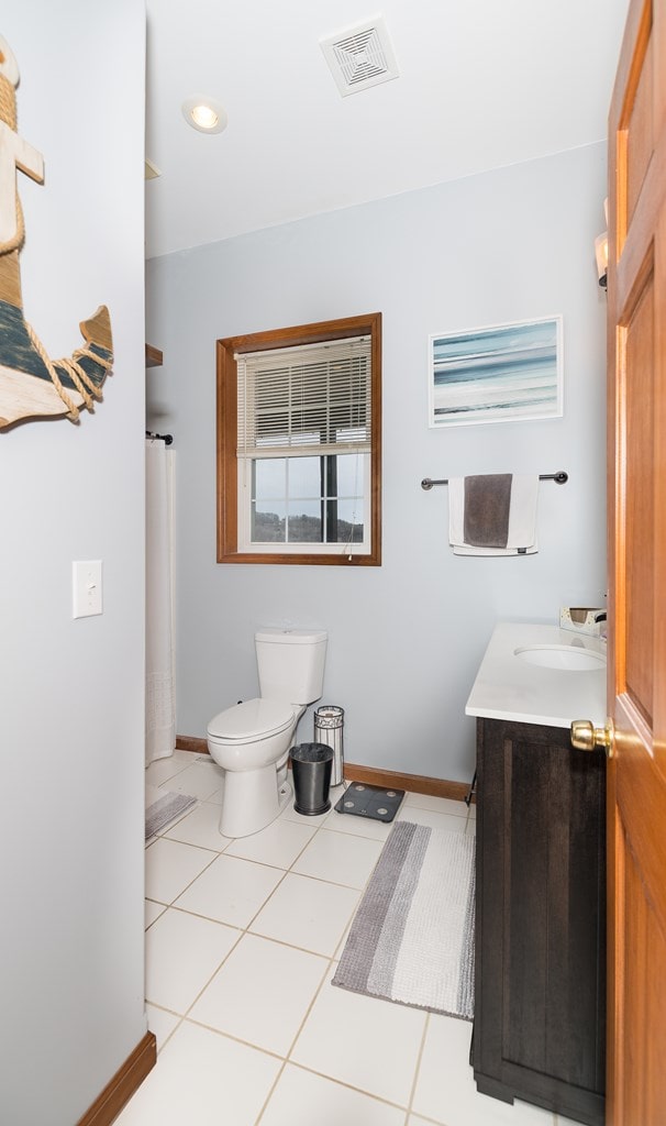 full bathroom with visible vents, toilet, tile patterned flooring, baseboards, and vanity