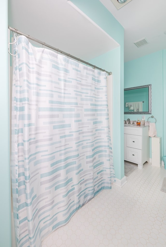 full bathroom with visible vents, vanity, a shower with shower curtain, and baseboards