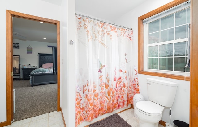 ensuite bathroom featuring tile patterned flooring, curtained shower, toilet, and ensuite bath