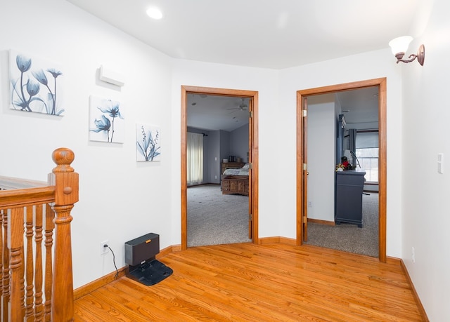 corridor featuring light wood finished floors and baseboards