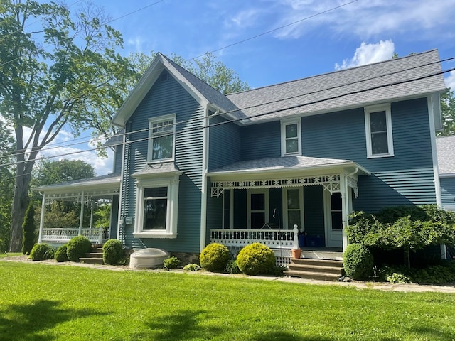 rear view of property featuring a yard and a porch