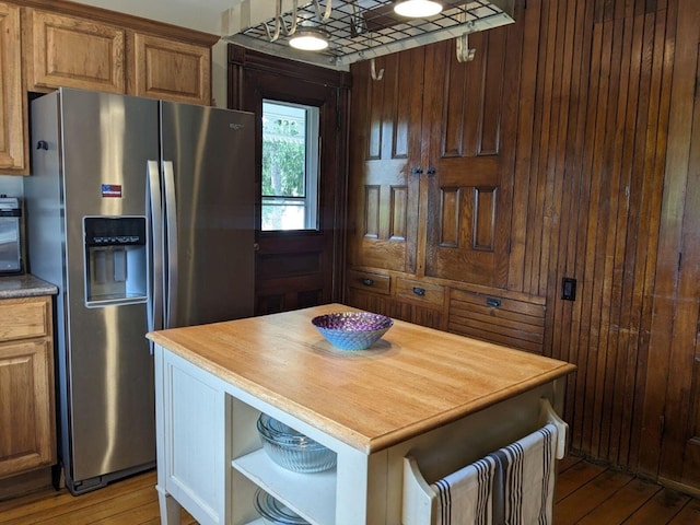 kitchen with butcher block counters, stainless steel fridge, light hardwood / wood-style flooring, and a kitchen island