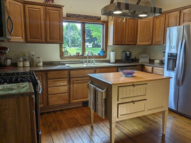 kitchen with a kitchen island, sink, stainless steel appliances, and dark wood-type flooring