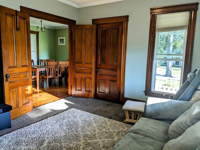 living room featuring carpet floors, crown molding, and a notable chandelier